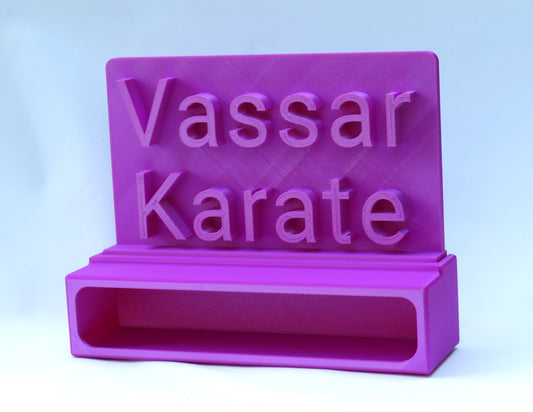 Custom topper with 'Vassar Karate' text attached to a 1 belt display on a light blue background