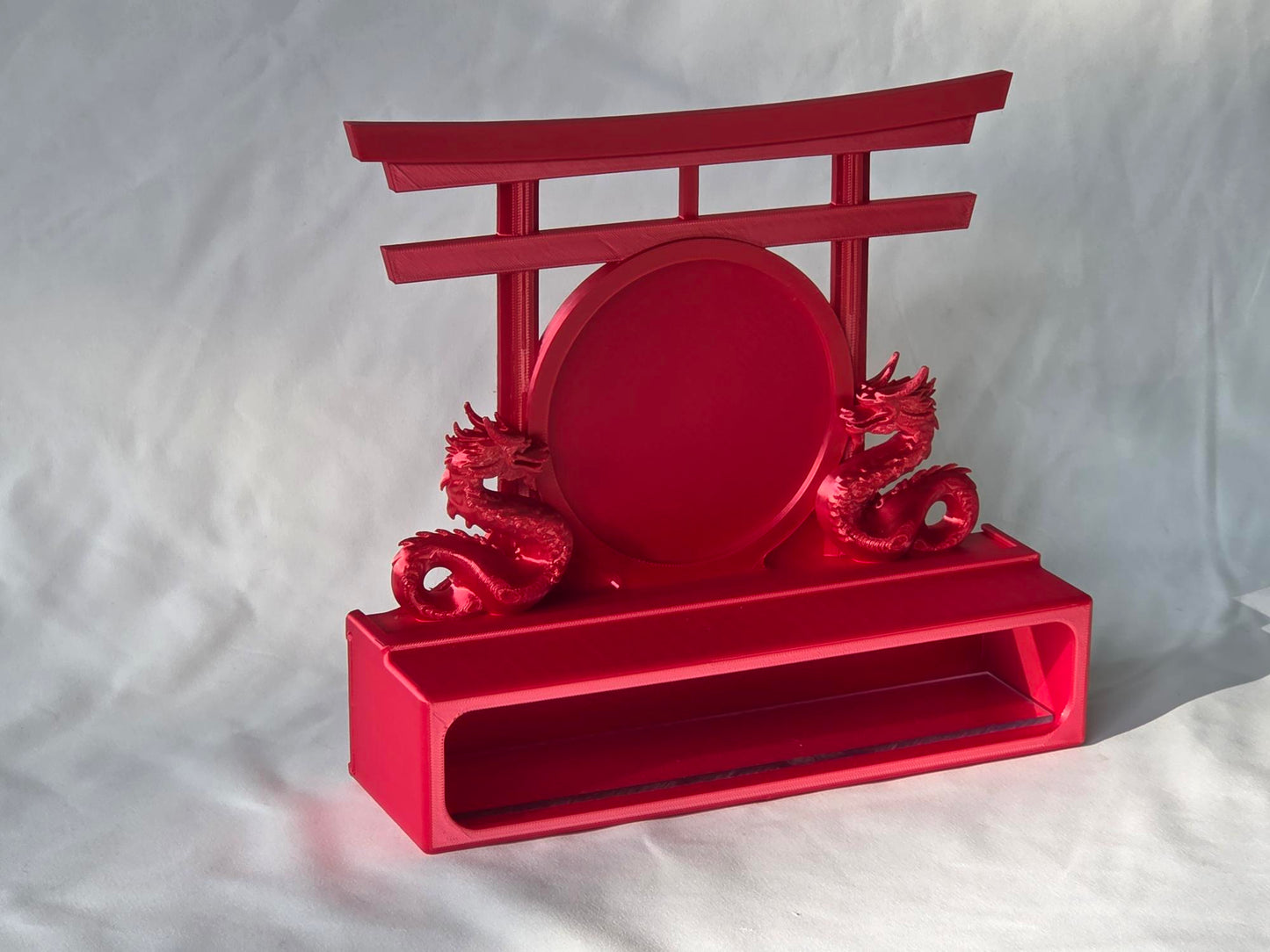 Red decorative topper with dragon design and torii gate on a white background