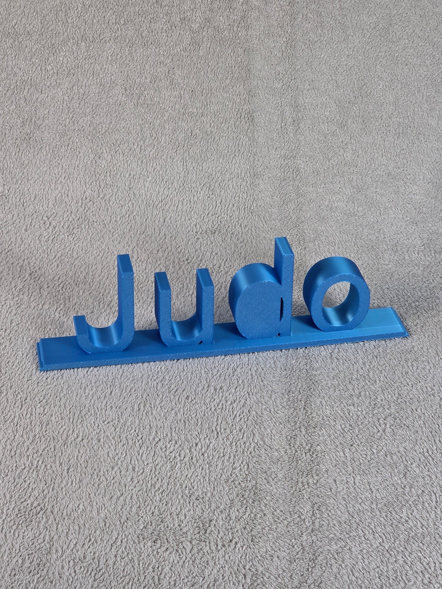Blue 'Judo' sign on a gray textured background