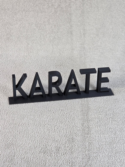 Black 'KARATE' sign on a textured gray background