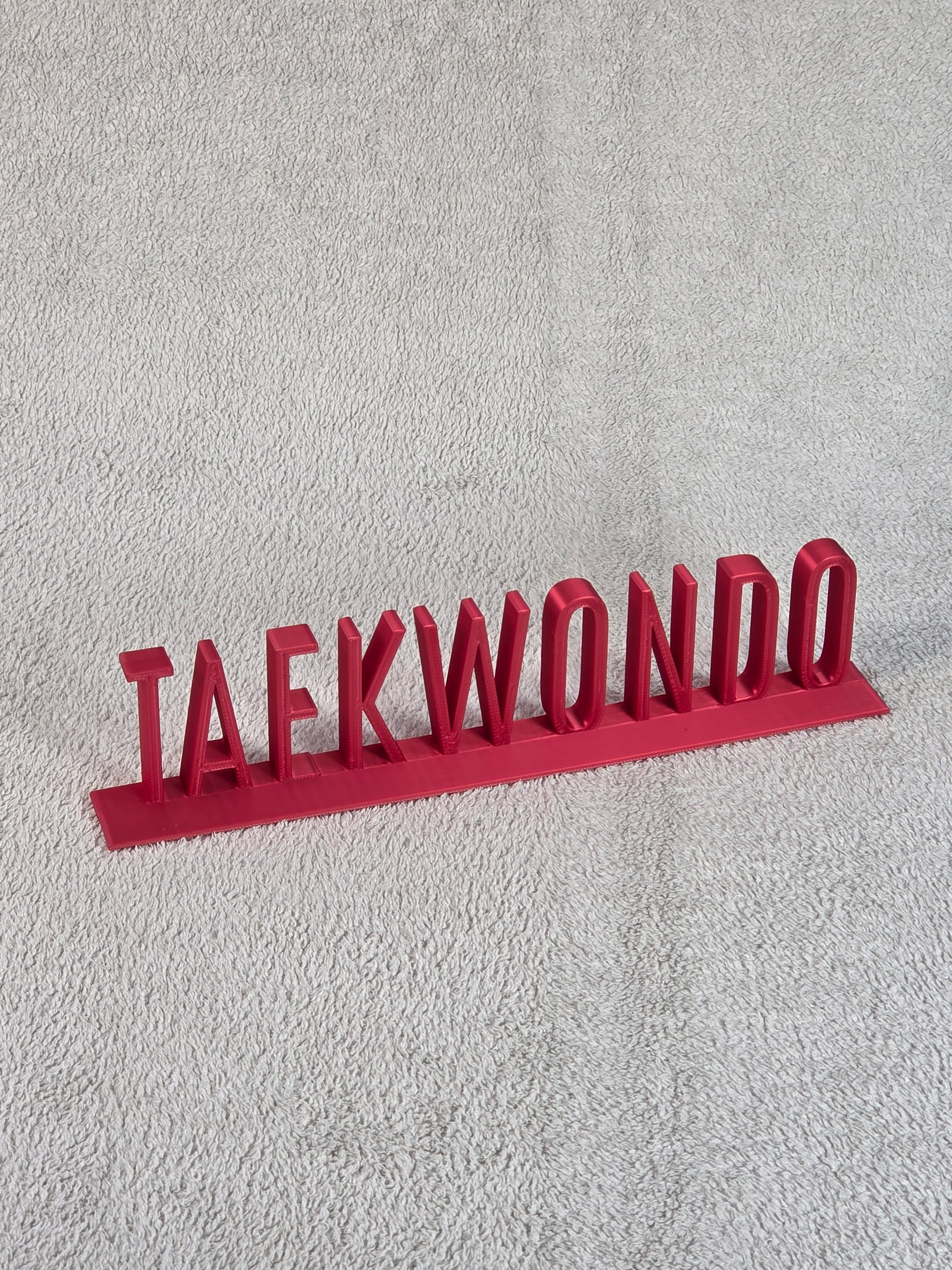 Red 'TAEKWONDO' sign on a textured gray background