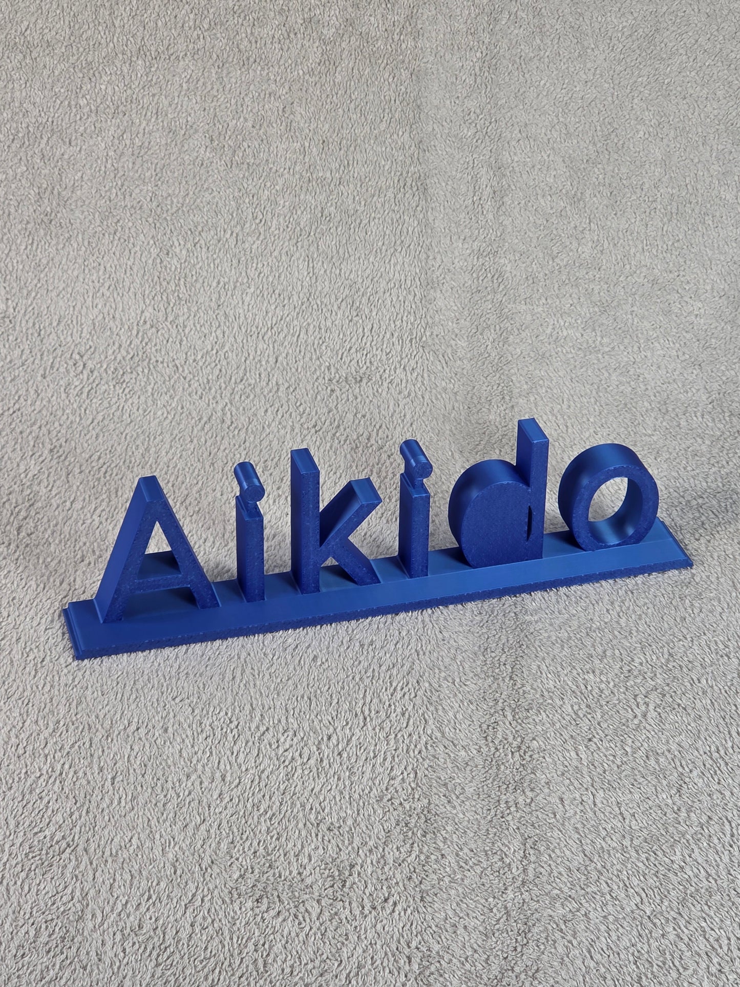 Blue 'Aikido' branding on a textured gray background