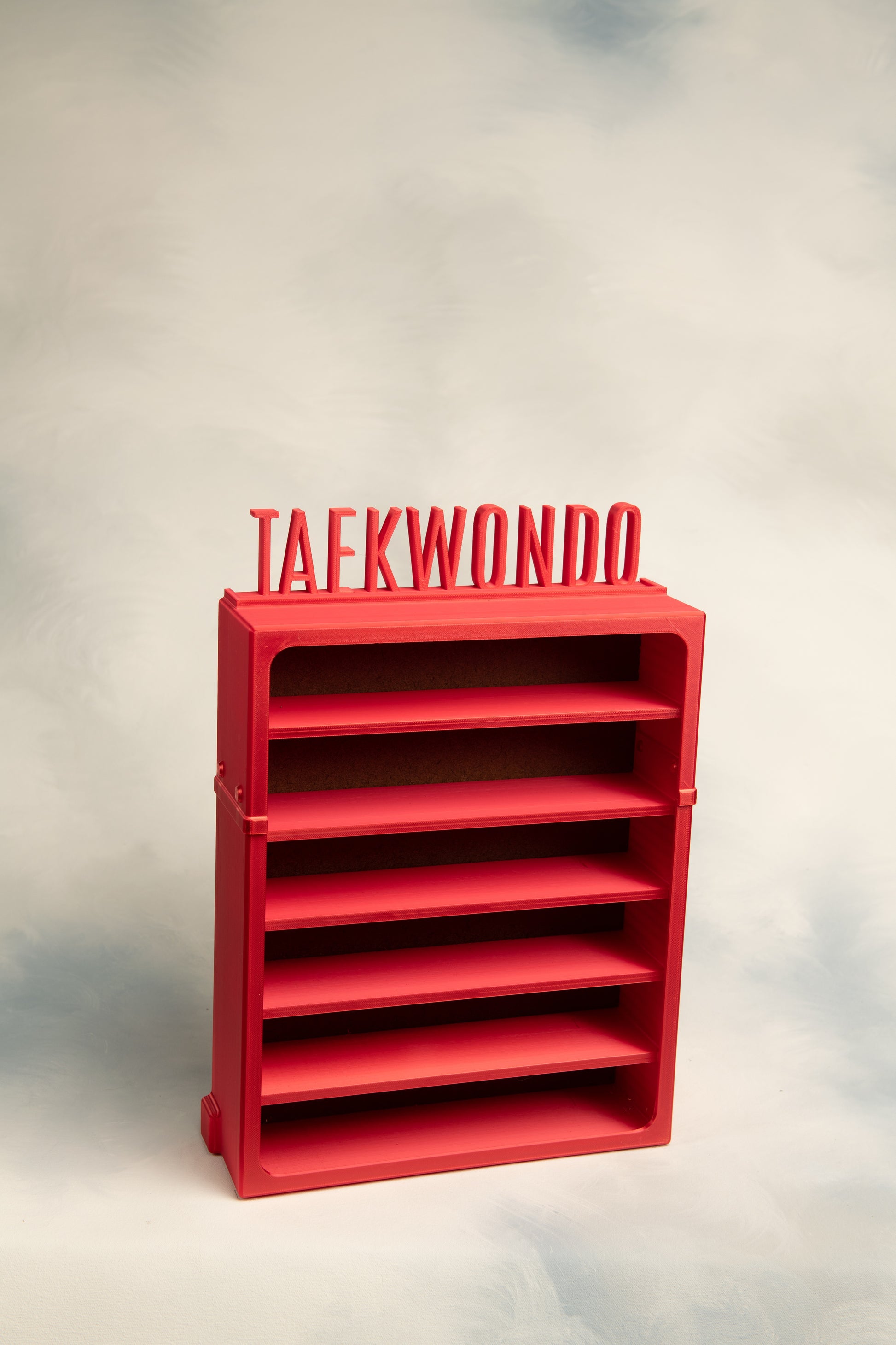 Red 6 belt display with 'TAEKWONDO' Topper on a light gray background
