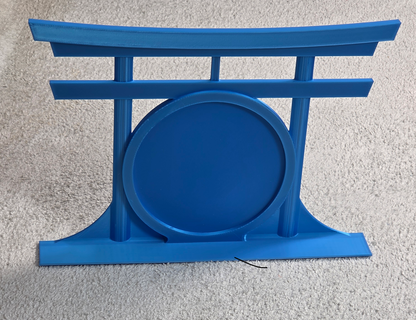 Blue decorative topper with a round patch area in front of a torii gate on a light gray background